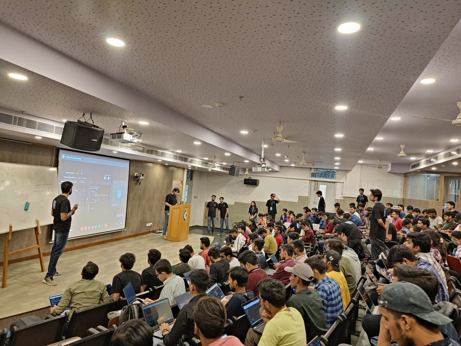 The Runtym lecture hall, filled with participants at laptops facing the stage.